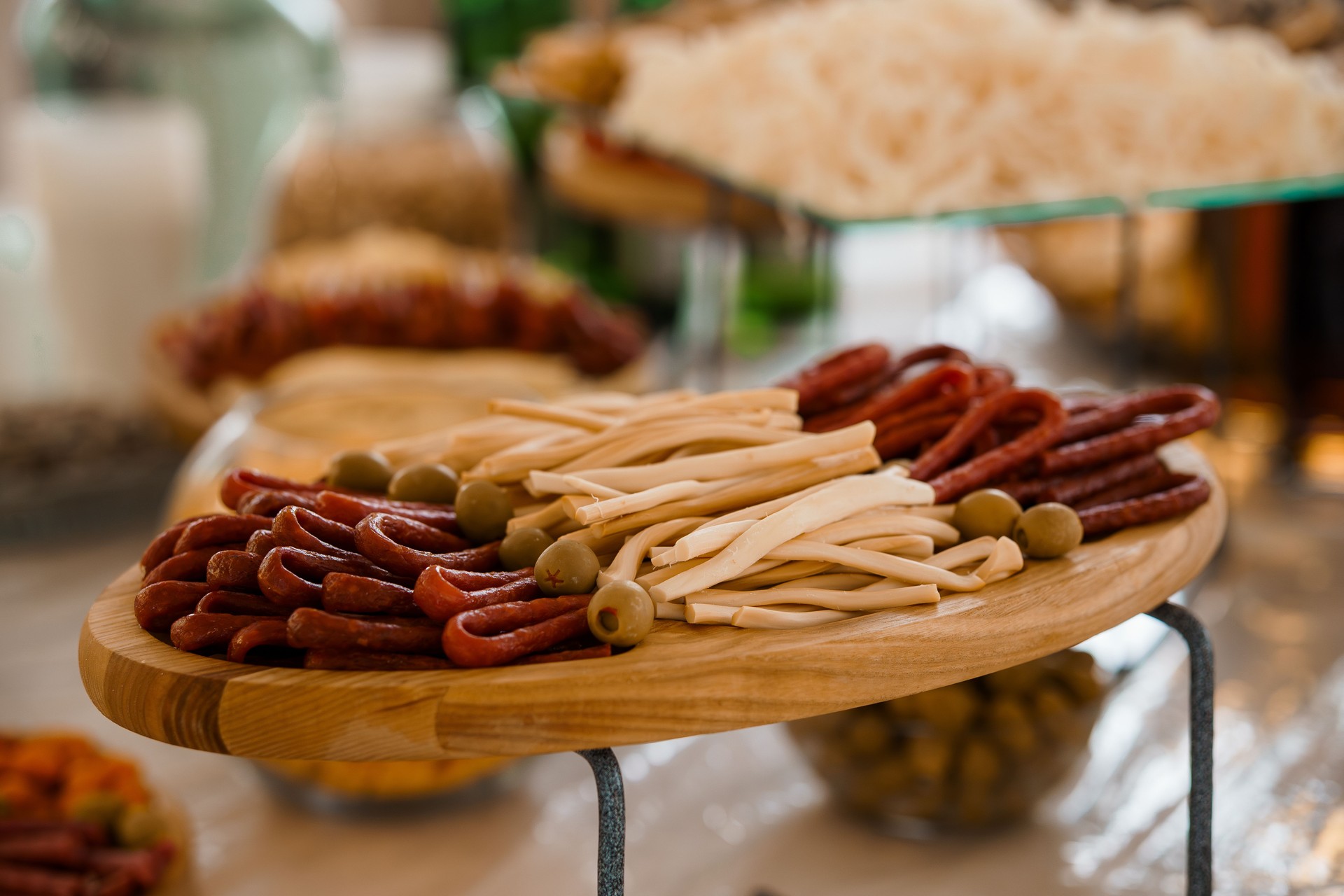 Abundant Charcuterie Board Display with Assorted Meats, Cheeses, Olives, and Breadsticks at an Elegant Food Event.